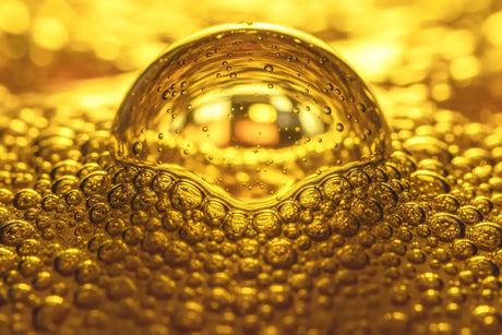 Macro photography of decarboxylating Type 3 CBD rosin showing golden oil bubble formation during low-temperature solventless extraction process